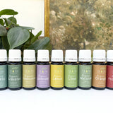 Row of essential oil bottles with labels in front of a plant