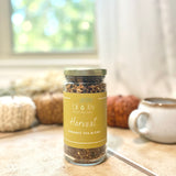 Jar of Harvest organic tea blend from Oil of Joy Apothecary on a table with pumpkins