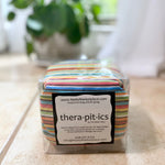 Striped cherry pit therapy pack on a wooden surface with a plant in the background
