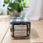 Thera-pit-ics product packaging on a tiled floor with a plant in the background
